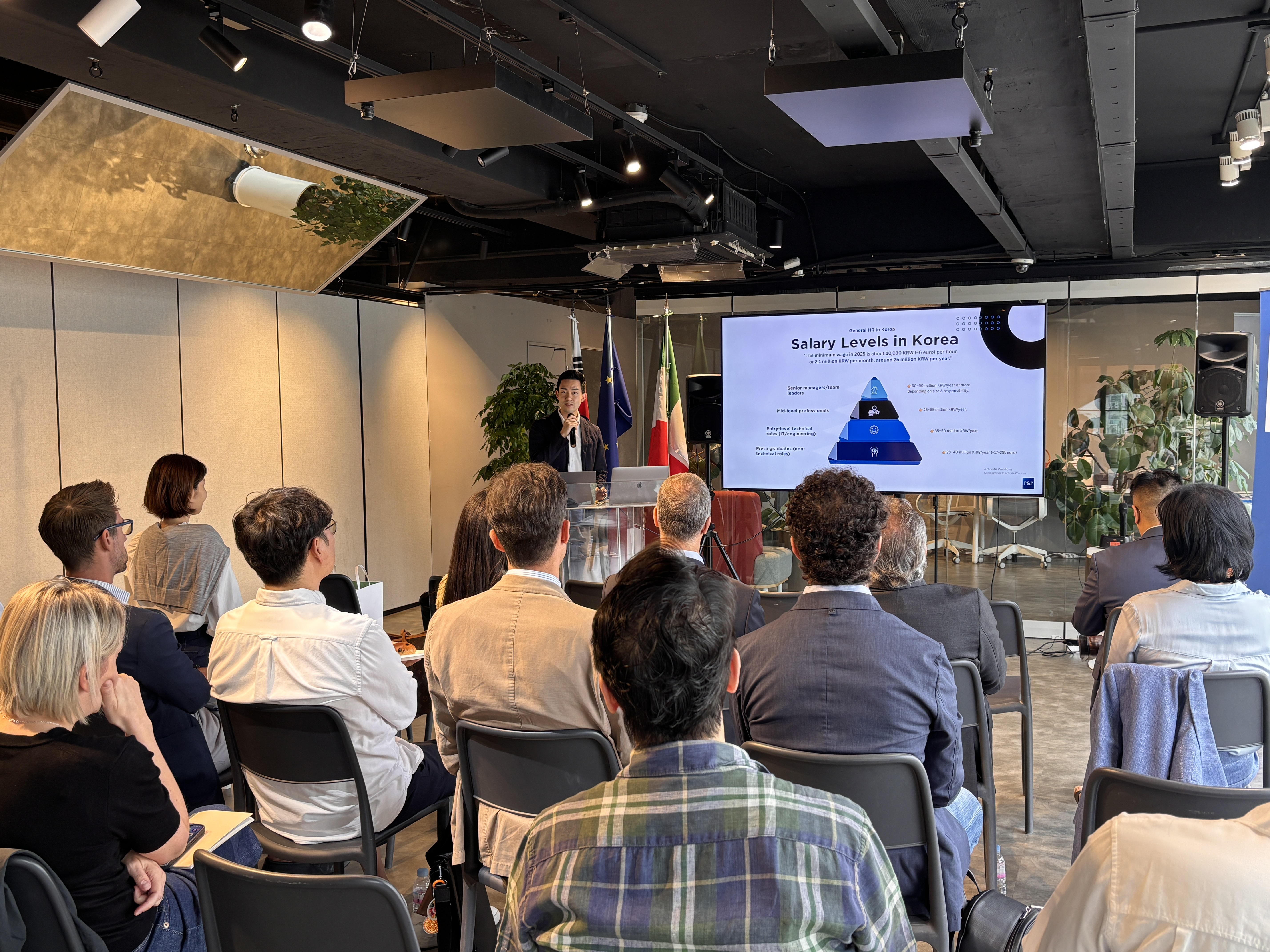 A man presenting at a crowd of people seated in front of him