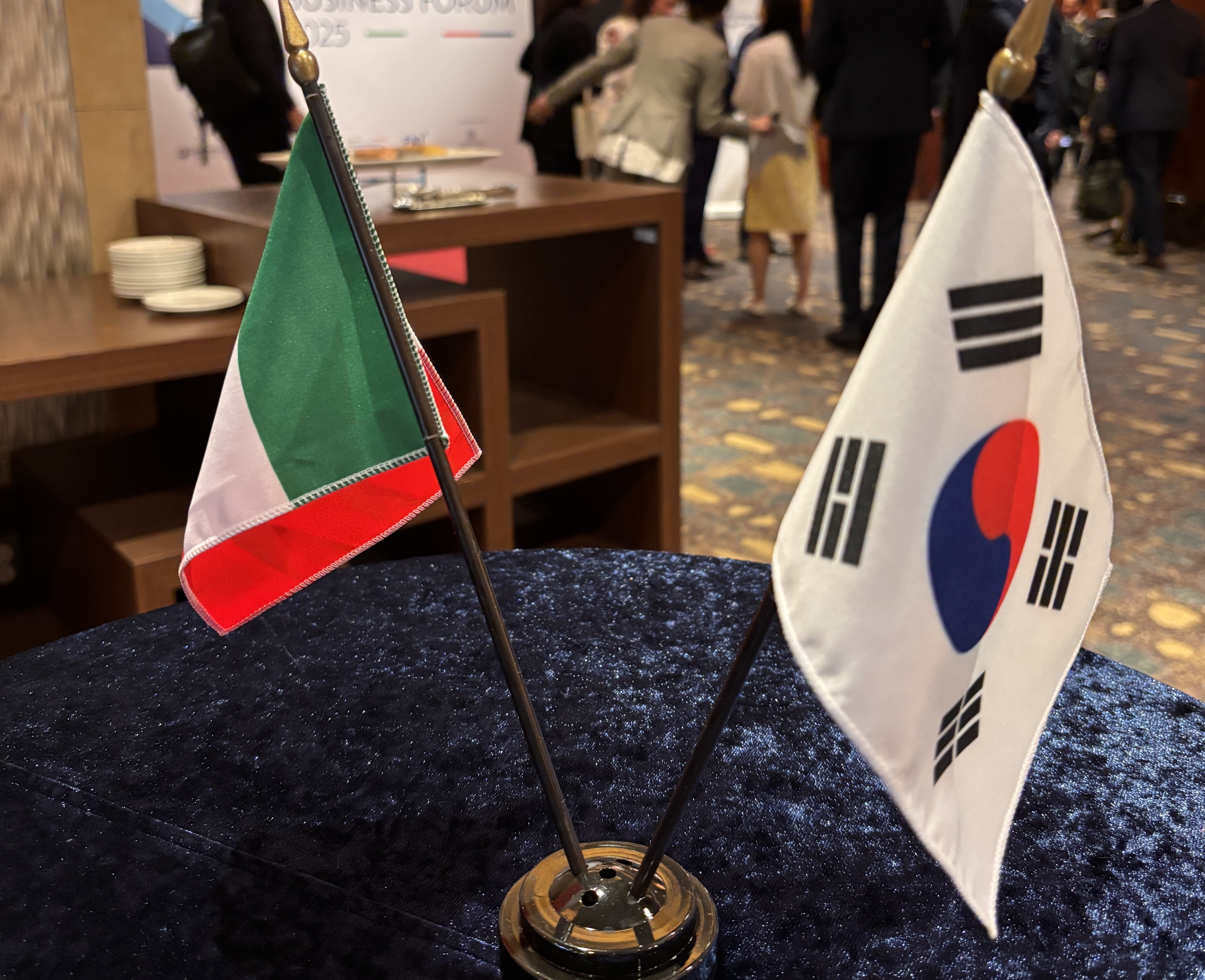 the italian and korean flags standing together as centerpiece on a table