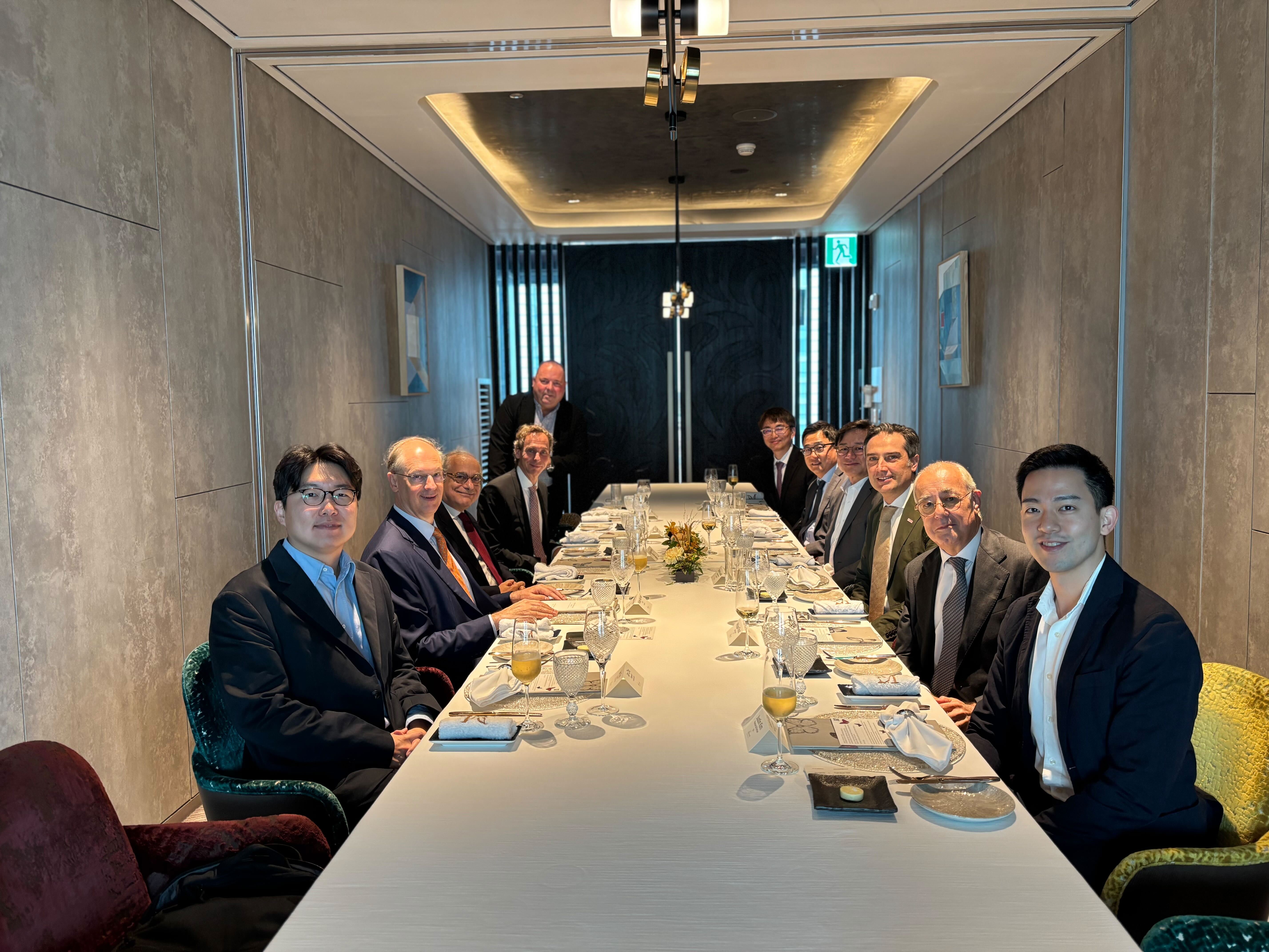 CEOs sitting on a long table set for lunch